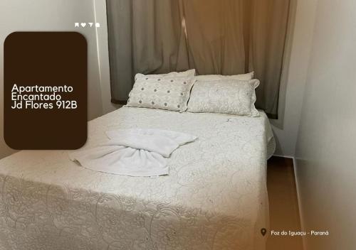 伊瓜苏APARTAMENTO ENCANTADO JD FLORES 912 - 1º andar的一张带白色床单和枕头的床
