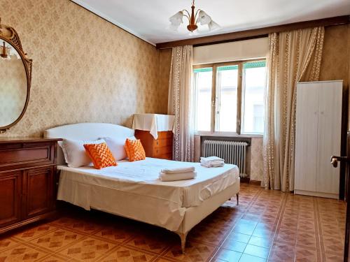 泰塞拉Locazione Turistica的一间卧室配有一张床、镜子和窗户