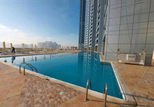 阿吉曼Luxury full sea view flat的一座高楼旁边的大型游泳池