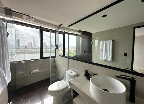 巴拿马城AmazINN Places Penthouse Deluxe, Skyline and Private Rooftop的一间带水槽和卫生间的浴室以及窗户。