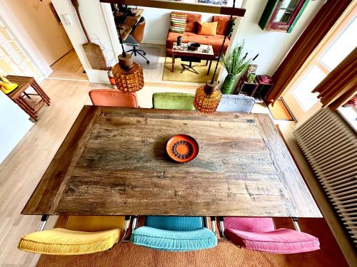 霍森斯2 værelses retro lejlighed på Torvet的客厅里一张桌子,四周摆放着五颜六色的椅子