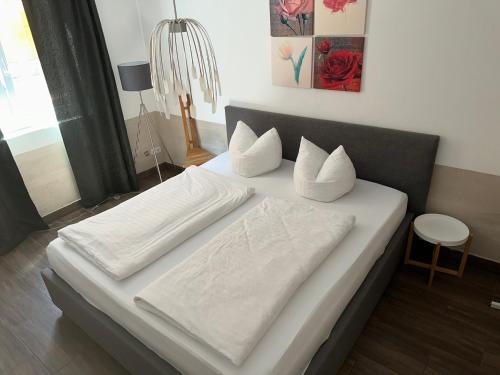 基彭海姆Apartment Stabel 8,1 km von Europa Park的一张配有白色床单和枕头的大床