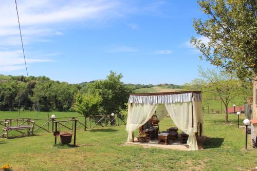圣焦万尼达索Casa vacanza Podere Ristoro的田野上带天篷的凉亭