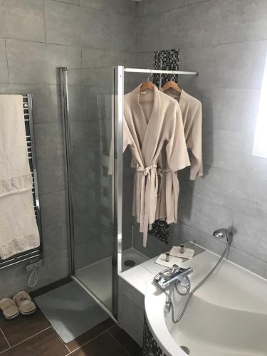 圣阿韦尔坦Saint-Avertin Maison la Tourangelle à partager en famille ou amis的带淋浴、盥洗盆和浴袍的浴室