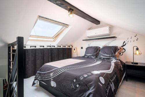盖拉德Life is music - Casa Vostra - Gaillard proche tramway-frontière的一间卧室配有一张带黑色棉被的床和窗户。