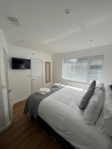 FeltonThe Annexe的卧室内的一张大白色床,带有窗户