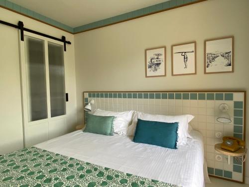 卡普费雷沙丘酒店的一间卧室配有带白色床单和蓝色枕头的床。