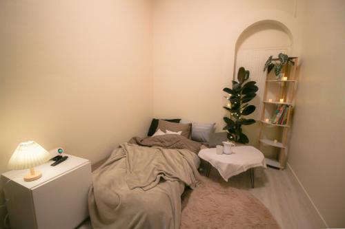 曼谷Napshot Guesthouse的一间卧室配有一张床和一张带台灯的桌子