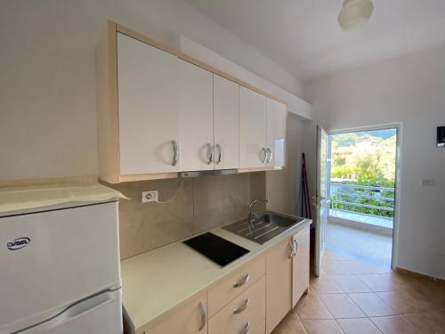 希马拉Wave n' Sea Apartments的厨房配有白色橱柜和水槽