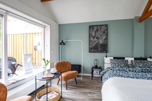 希尔登Huisje Sasa的一间拥有蓝色墙壁的卧室、一张床和窗户