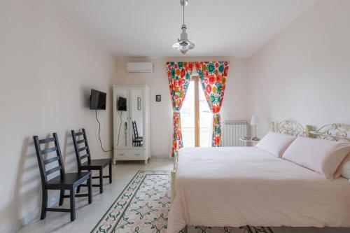 GrassanoB&B Vigna del Duca的一间卧室配有床、椅子和窗户