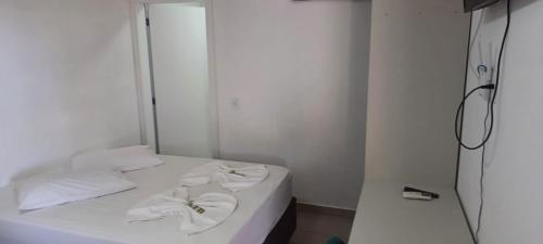 佩尼亚Pousada Casa Amarela Brisa Parque的卧室配有白色床和毛巾