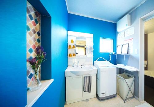 白滨風 - Family House KAZE -的蓝色的浴室设有水槽和洗衣机。