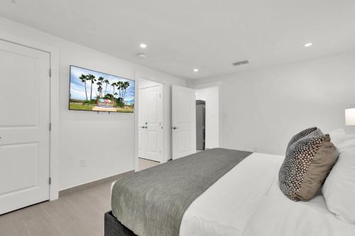 南帕诸岛Spectacular Ocean-View Condo in Beachfront Resort的白色卧室配有一张床,墙上挂着一幅画