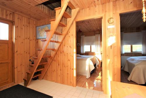 阿克雷里Eys Cabin的客房设有两张床和木制楼梯。