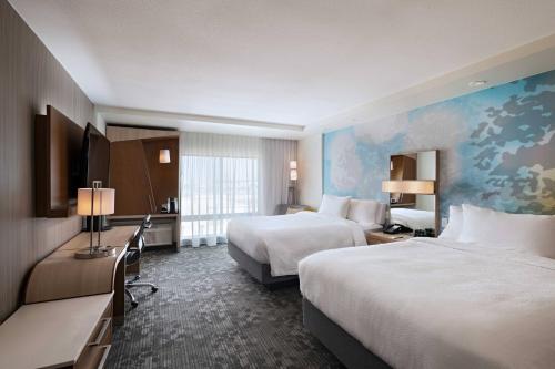 大草原城Courtyard Dallas Grand Prairie的酒店客房配有两张床和一张书桌