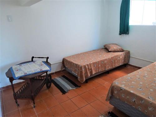 阿瓜斯-迪圣佩德罗Mi Casa, Águas de São Pedro的一间设有两张床和一张桌子的房间