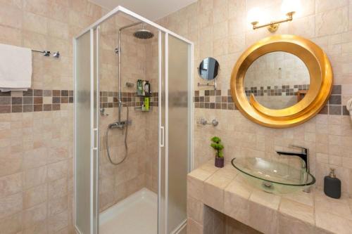 阿依纳帕Cape Serenity Mansion的带淋浴、盥洗盆和镜子的浴室