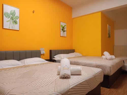 峇六拜Cozy Private Family Room in Bayan Lepas的黄色墙壁客房的两张床