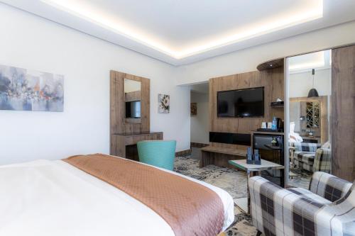 麦地那Gacine Hotel Al Tahlia的一间酒店客房,配有一张床和一台电视