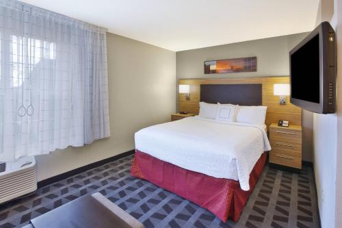 伊根圣保罗机场/伊根明尼阿波利斯广场套房酒店的配有一张床和一台平面电视的酒店客房