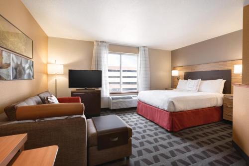 丹佛TownePlace Suites by Marriott Denver Downtown的酒店客房,配有床和沙发