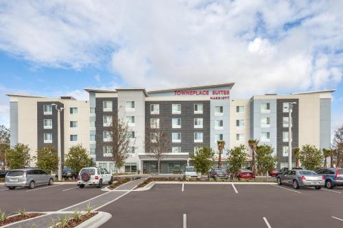 奥兰多TownePlace Suites by Marriott Orlando Altamonte Springs/Maitland的停车场内停放汽车的大型建筑