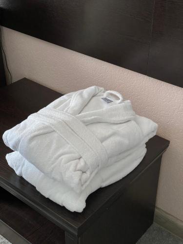 塔拉兹Думан Холл Отель的一张桌子上摆着的一堆白色毛巾