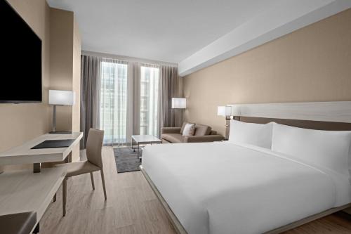 华盛顿AC Hotel by Marriott Washington DC Capitol Hill Navy Yard的酒店客房设有一张白色大床和一张沙发。
