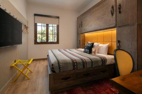 圣巴巴拉Moxy Santa Barbara的一间卧室配有一张带木制床头板的床