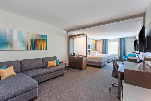 埃尔卡洪圣地亚哥埃尔卡洪万怡酒店 的酒店客房设有一张沙发和一张床