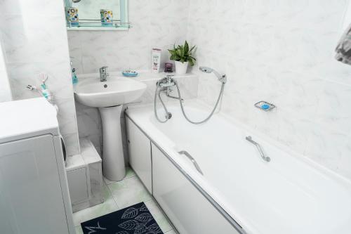 阿拉木图Золотой квадрат 60 кв2的白色的浴室设有水槽、浴缸和卫生间。
