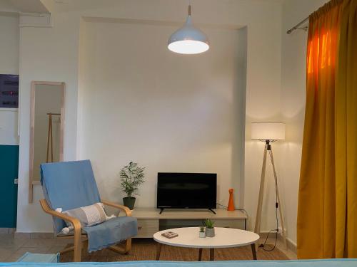 科洛皮奥Helen's cozy studio (close to the airport)的客厅配有蓝色椅子和电视