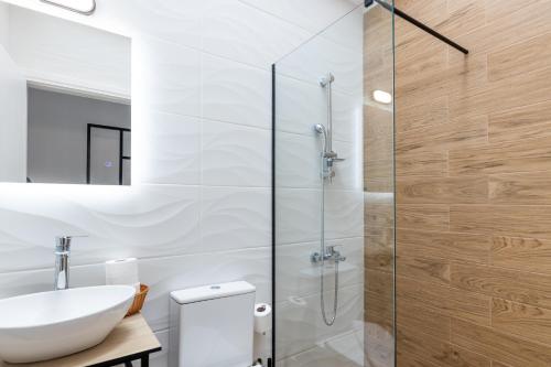 卡拉马塔Pagani Blue - Luxury Maisonette B3的一间带水槽和玻璃淋浴的浴室