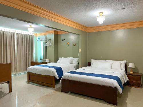 曼塔Apart Hotel Hamilton的一间卧室设有两张床和大窗户