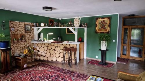 维斯瓦Rezydencja Nad Potoczkiem的客厅设有绿色的墙壁和带桌子的酒吧
