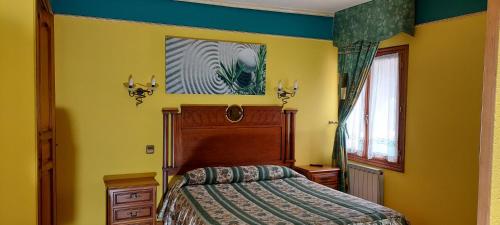 莱萨卡如洛尔贝里奥酒店的卧室配有一张床,墙上挂有绘画作品