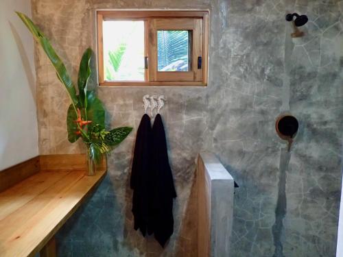 博卡斯德尔托罗Casa Salvaje Vacation Rentals的带淋浴和黑色毛巾的浴室