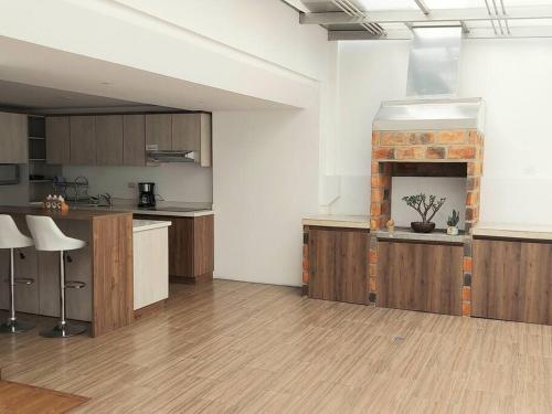 洛哈Departamento nuevo, elegante y muy cómodo.的一个带木制橱柜和壁炉的大厨房