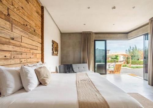 瓜达鲁佩镇Chateaux del Valle Vacational Homes的一间卧室设有一张带木墙的大床