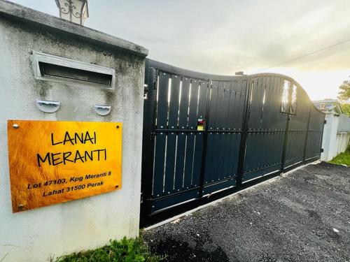 怡保Lanai Meranti的房屋一侧有标志的黑色门