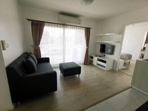 华欣Luxury 2 bedrooms condo in Kho Takiab的客厅配有黑色沙发和电视