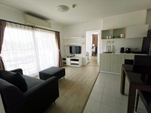 华欣Luxury 2 bedrooms condo in Kho Takiab的带沙发和电视的客厅以及厨房。