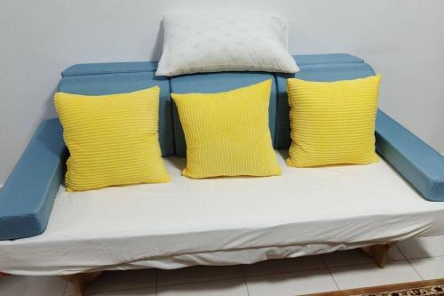 汝来HMM Lili - Nilai的一张带三个黄色枕头的床