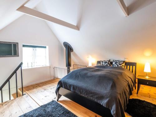 瓦伊厄斯斯特兰德Holiday home Vejers Strand XIX的一间卧室配有一张带黑色棉被的床和窗户。