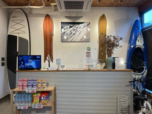 白川村GuestHouse Shirakawa-Go INN的墙上有冲浪板的商店里的柜台