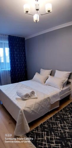 阿拉木图Алматушечка的卧室配有一张带白色床单和枕头的大床。