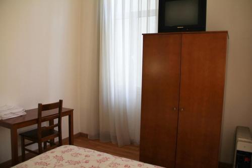 波尔图爱克扎果酒店的卧室配有木橱柜顶部的电视。