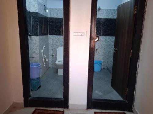 巴德拉恰拉姆SRI BHAVYARESIDENCY的一间带卫生间和玻璃门的浴室