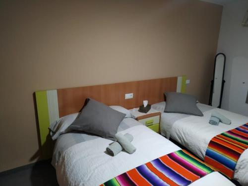 库列拉Bonito apartament a 3 minutos de la playa的两张睡床彼此相邻,位于一个房间里